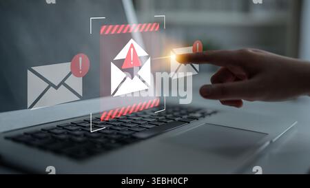 A close-up of a hand interacting with a laptop screen displaying email notifications, emphasizing urgent messages and digital communication in a Stock Photo
