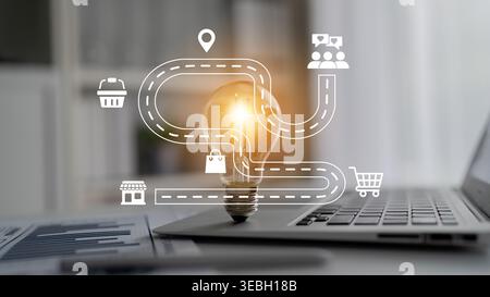 This conceptual image illustrates a light bulb symbolizing ideas and innovation, with icons representing business pathways and technology on a laptop Stock Photo