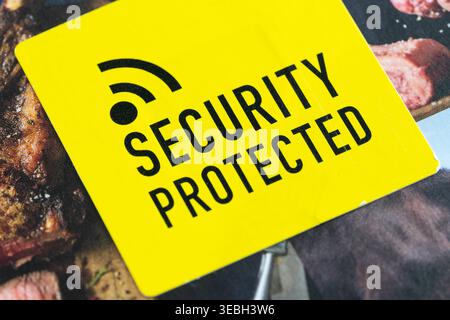 Yellow RFID (Radio Frequency Identification) tag containing a chip and antenna on a pack of steak, used for theft deterrence on high value food. UK Stock Photo