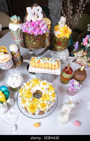 Vertical view of Easter table with cakes, eggs, and decorative bunnies. Stock Photo