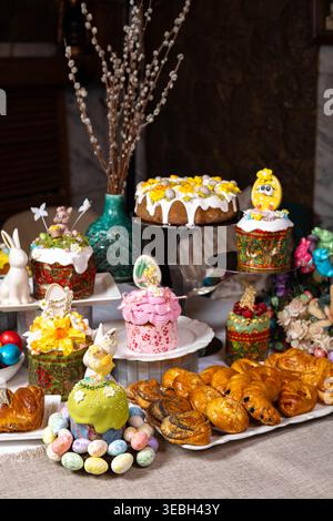 Vertical view of Easter table with cakes, eggs, and decorative bunnies. Stock Photo