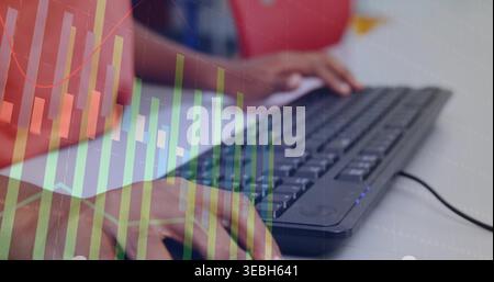 Typing child's hands pressing wired keyboard on white table, with red shirt and chart overlay Stock Photo