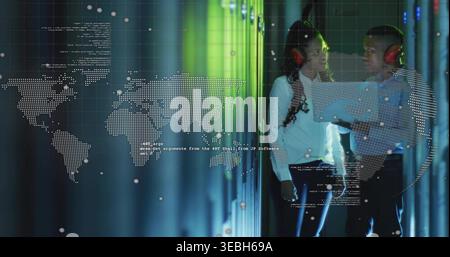 Standing 2 techs in shirts and red-headsets checking laptop in server room with map, copy space Stock Photo