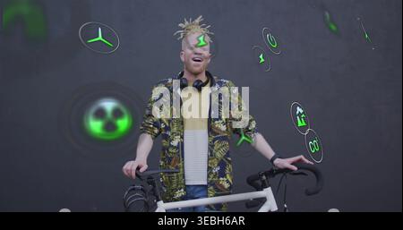 Standing man in patterned jacket holding white road bicycle at dark gray wall, showing green icons Stock Photo