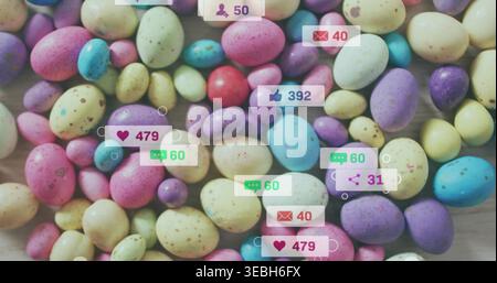 Covering dense cluster of pastel speckled candy eggs on light wood tabletop, showing social badges Stock Photo