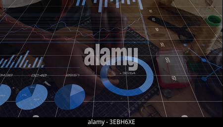 Working male wearing dark longsleeve assembling parts on bench with grid mat and blue data overlay Stock Photo