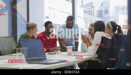 Reviewing six coworkers in business casual studying documents at office, laptop phone Play overlay Stock Photo