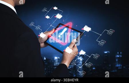 Businessman Holding Tablet with Warning Symbol and Digital Data Flow in Urban Nightscape Background for Technology and Security Concept Sigmoid Stock Photo