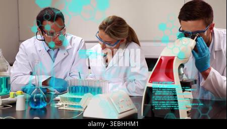 Pipetting, three researchers in lab coats, goggles, gloves working at lab bench with test tube rack Stock Photo