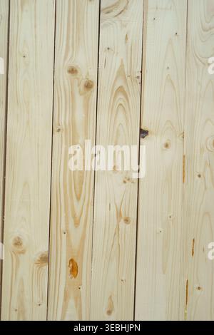 Light-colored wooden boards arranged vertically, showing natural grain and knots. Ideal background texture for construction, interior design, or Stock Photo