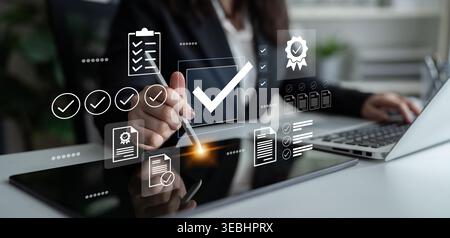 A business professional interacts with a digital tablet, signing documents and checking tasks in a sleek office environment, symbolizing modern Stock Photo