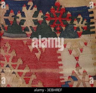Traditional kilim rug presenting a close-up view of its woven texture, displaying colorful geometric patterns and intricate details reflecting the art Stock Photo