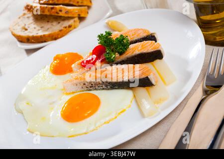Fried salmon with scrambled eggs and asparagus Stock Photo