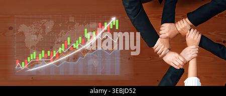 This image captures a collaborative business environment showcasing hands joining together above a chart, symbolizing teamwork and strategic growth in Stock Photo