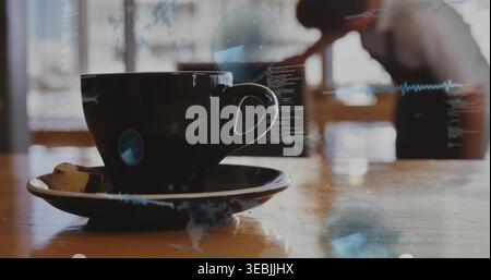 Framing dark ceramic cup with saucer on cafe table, sugar cube, blurred figure and digital overlays Stock Photo