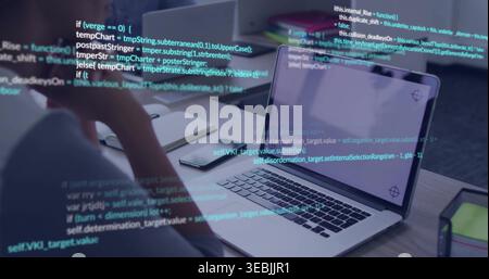 Coding developer resting chin on hand, reviewing code at desk with open laptop and smartphone Stock Photo