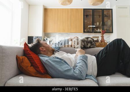 Young man playing with little kittens. Care and love for animals Stock Photo