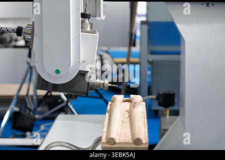 Wood milling on CNC machining center with tilting aggregate head. Selective focus. Stock Photo