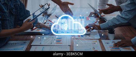 A team collaborates in a modern office setting, focusing on data security strategies with cloud computing visuals. Innovative discussions on Stock Photo