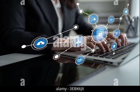 A professional woman engages with a laptop, surrounded by digital security icons that illustrate modern technology and connectivity in a contemporary Stock Photo