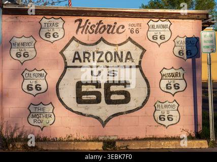 Historic route 66 mural painted on a pink brick wall, displaying route shields for arizona, california, texas, and other states, Holbrook, usa. Stock Photo