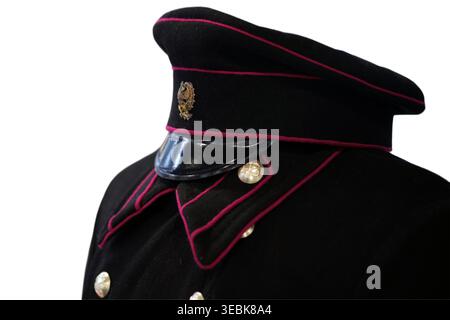 Black railway conductor uniform with peaked cap. Vintage train worker outfit worn by man. Traditional railway attire isolated on white background. Tra Stock Photo
