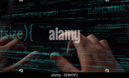 A close-up of hands typing on a backlit keyboard, with programming code reflecting off a glass surface. This image captures the essence of technology Stock Photo