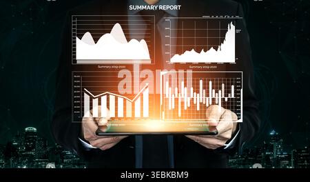 A businessman holds a digital tablet displaying a colorful summary report with various charts and graphs, set against a modern financial backdrop Stock Photo