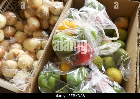 Box of fresh assorted fruit produce wrapped in plastic bag ready for market sale offering feeling of abundance and fresh agriculture harvest Stock Photo
