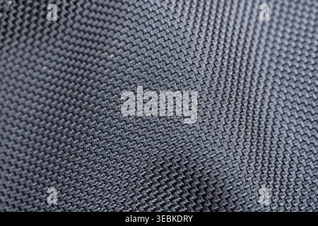 Detailed texture background featuring dark gray and black fabric weave pattern material macro closeup evoking strong feeling of reliable industrial to Stock Photo