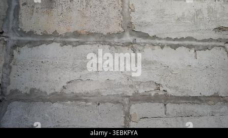 Gray concrete block wall texture featuring visible mortar and lines, creating a repeatable pattern ideal for various design applications Stock Photo