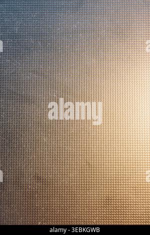 Abstract background texture showcases dark gray vertical ripples highlighted by striking gold reflections and small areas of green. Stock Photo