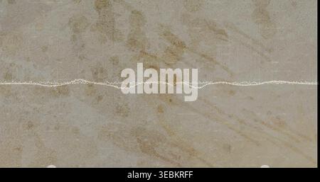 Displaying stone slab in close-up with white dotted waveform line across center, dark edges Stock Photo