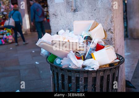 garbage piles inside dumpster in venice city, consequence of over tourism, litter bags overflow trash cans Stock Photo