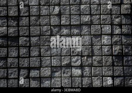 Top view of dark grey square stone pavers creating a geometric grid pattern Stock Photo