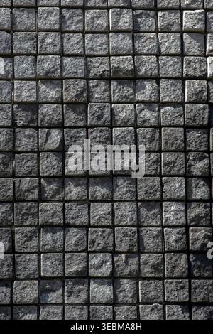 Top view of dark grey square stone pavers creating a geometric grid pattern Stock Photo