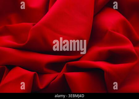Abstract red silk fabric background with deep folds and drapery for luxury design. Stock Photo
