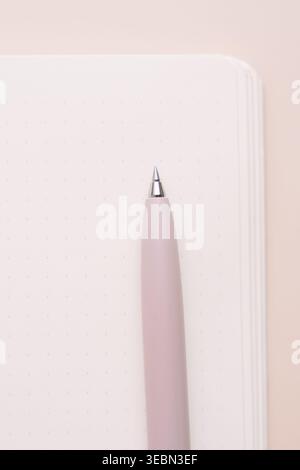 Pink pen and blank notebook page on beige background Stock Photo