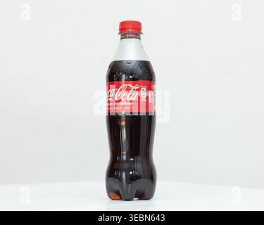 Almeria, Spain, April 23, 2026: Realistic photograph of a 500ml clear plastic PET bottle filled with dark carbonated Coca-Cola, showing the label deta Stock Photo