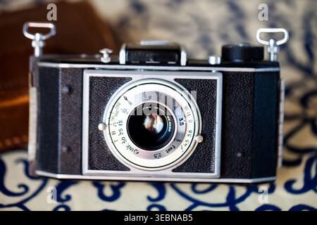 Vintage silver and black 35mm film camera on a patterned background Stock Photo