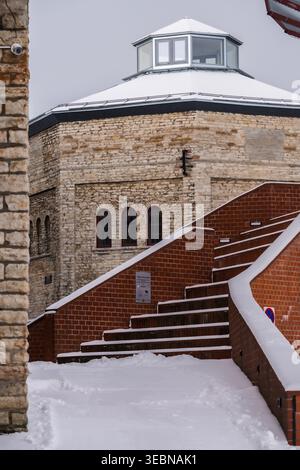 View of the Kiek in de Kök artillery tower stands tall, adorned with snow, next to brick stairs covered in fresh powder, , Tallinn, Estonia. Stock Photo