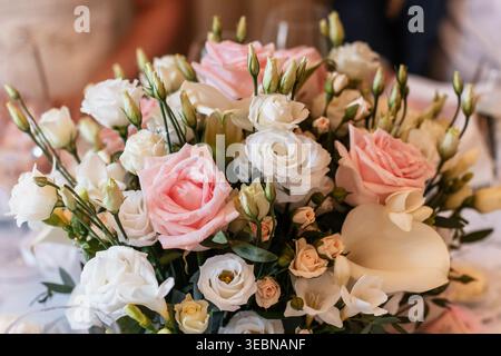 Wedding bouquet of pink and white roses decorating reception table Stock Photo