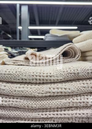 Stack of textured beige linen towels neatly folded on a shelf Stock Photo