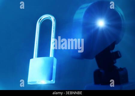 Close-up futuristic robot head in a sleek blue cyber environment, illuminated with soft cinematic lighting and subtle lens flares. A metallic padlock Stock Photo
