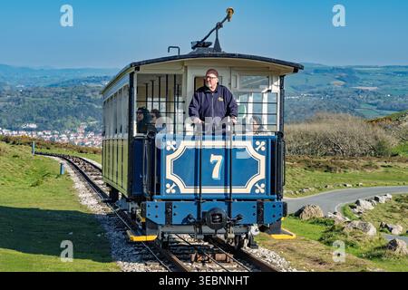 A Victorian ropeway tram moves smoothly along the hillside of the Great Orme in Llandudno. Passengers enjoy breathtaking scenery and a serene atmosphe Stock Photo