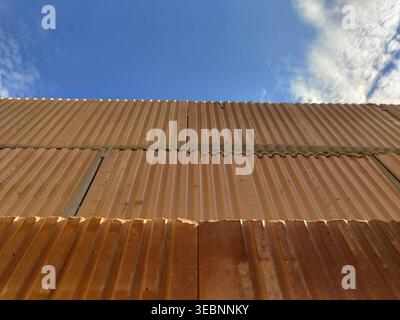 Close view of clay construction blocks with grooves and mortar joints forming wall structure against sky background. Construction, masonry, building m Stock Photo