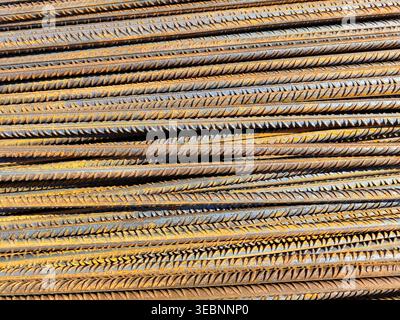 Rusted steel reinforcement bars stacked in dense horizontal layers with ribbed texture and oxidation on construction site. Building materials, metal i Stock Photo