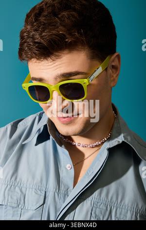 Confident young man showcases his summertime style with bright sunglasses and casual attire. Stock Photo