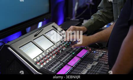 Mixing operation. Professional audio or sound engineers operating digital mixing consoles in studio or live mix perform. Sound control music productio Stock Photo