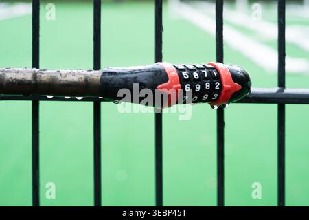 Combination lock on a rainy day securing a gate at a sports field in Berlin, Germany Stock Photo